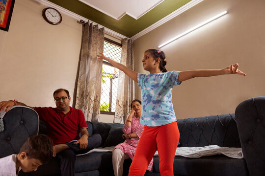 daughter dancing with her parent and brother in background
