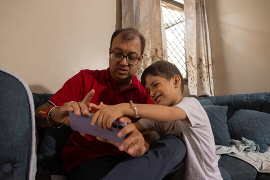 father and son watching a video on smart phone