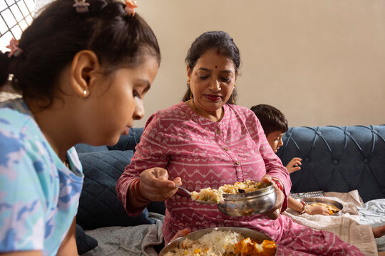 mother serving more food to her daughter