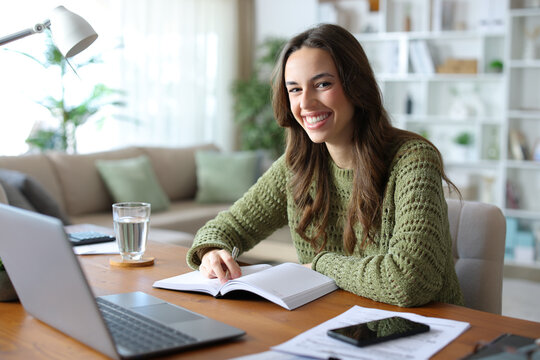 Happy teleworker with paper agenda looks at you
