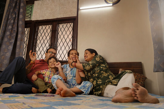 a happy moment captured of family with mother pinching her daughter's cheek