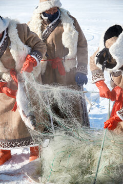 People ice-fishing on the frozen lake during the cold winter.