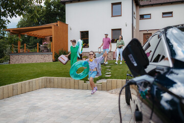 Naklejka premium Happy family leaving home for summer vacation with luggage and pool toys.