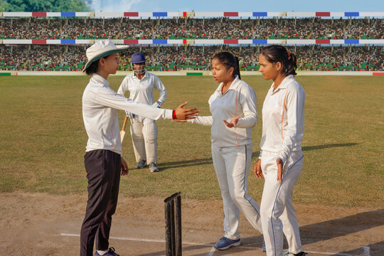 Umpire and players discuss a decision on the cricket field