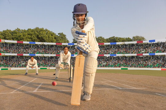 Batsman preparing to play a shot in a cricket match