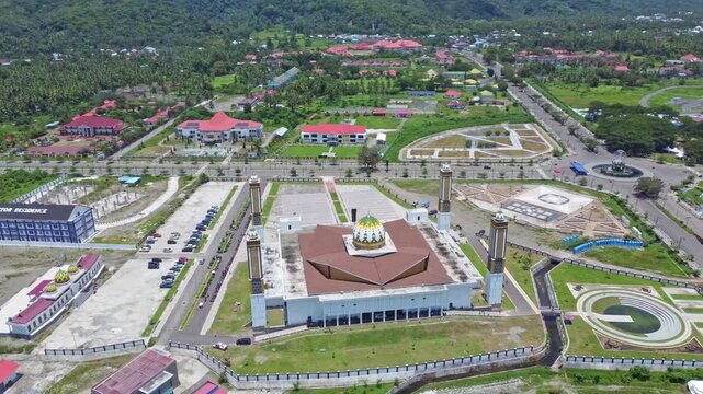 An aerial shot of a magnificent mosque Masjid Raya Shaful Khairaat Sofifi Tidore with mountains and the sea. Ideal for projects on religion, travel, and culture