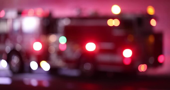Abstracted de-focused bokeh view of fire engine emergency assets arriving on scene at night.