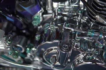 Fototapeta premium Close-up of a customized shiny chrome motorcycle engine block with green anodized titanium bolts.