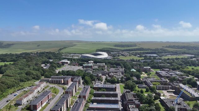 Cinematic aerial drone flyover of University of Sussex campus and nearby American Express Stadium showcasing modern architecture and the Sussex landscape in 4K.