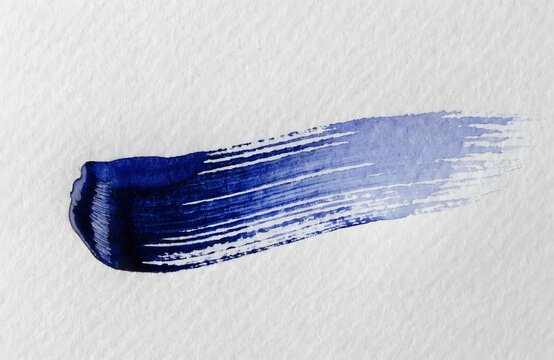 Blue paint brush stroke on white textured background with gradient effect