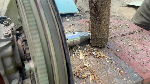 Man splitting log with electric screw wood splitter close up