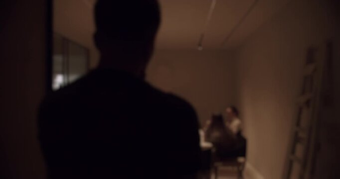 Ominous shot of a man walking down a dimly lit hallway towards a secret meeting in progress, creating a suspenseful and clandestine atmosphere perfect for thriller or espionage concepts