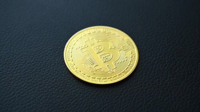 Golden bitcoin coin on dark textured surface shows cryptocurrency logo