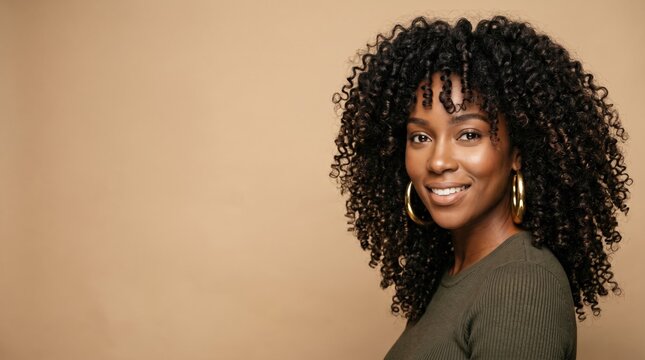 Dark skinned woman with voluminous curly hair wearing a green top and large gold earrings. Ideal for beauty, fashion, or portrait photography projects.