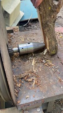 Close up of a screw log splitter splitting a piece of firewood