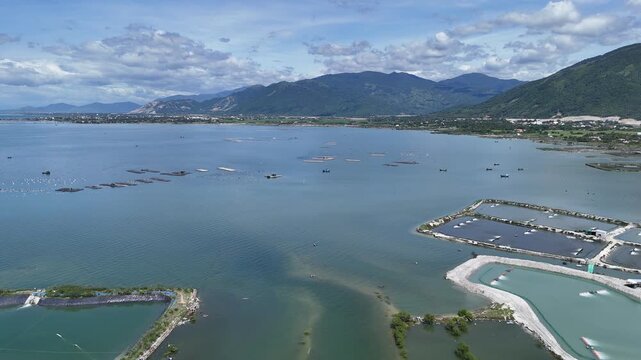 Drone footage captured above a fishing village in Van Phong Bay, Khanh Hoa Province, Vietnam. The aerial view documents coastal homes, fishing boats, and surrounding waters within one of Vietnam's lar