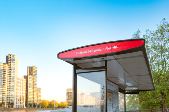 Newly constructed central London bus stop seen by the river Thames. South of the river are tall apartment complexes seen in the evening light.