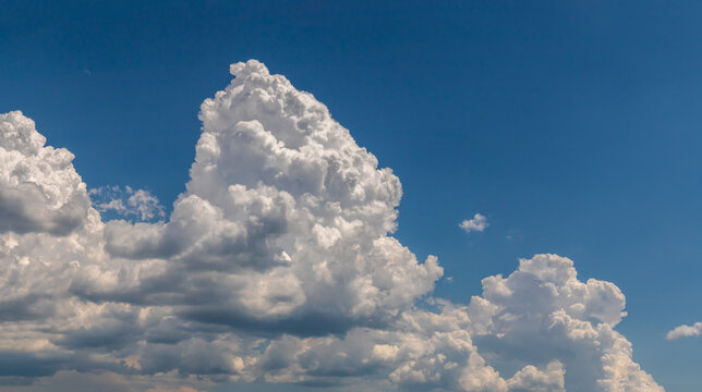 White towering cumulus clouds against a bright blue sky