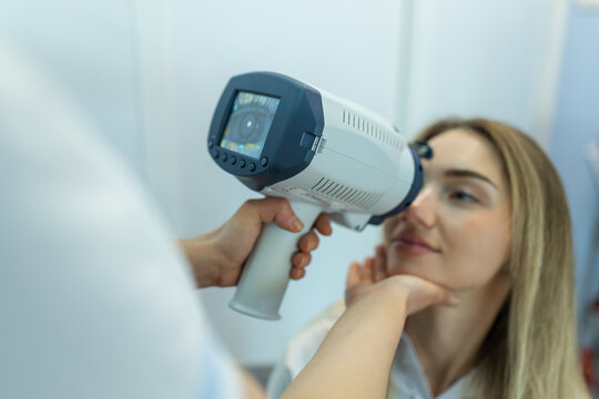 Young woman undergoing computerized eye examination at ophthalmology clinic