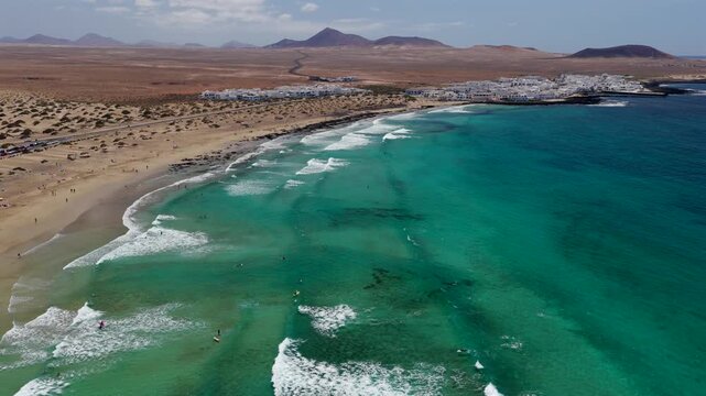Aerial Flyover above  Famara Beach Cliffs and Coastal Village in Northwest Lanzarote