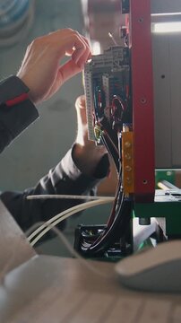 Electrician on overalls is working with energy panel and machinery equipment on plant