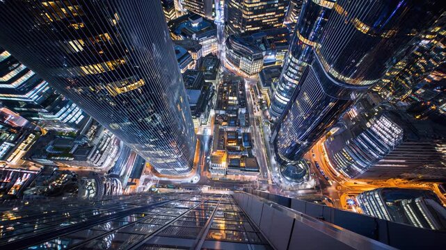 Aerial view of a modern city skyline at night with illuminated skyscrapers and traffic