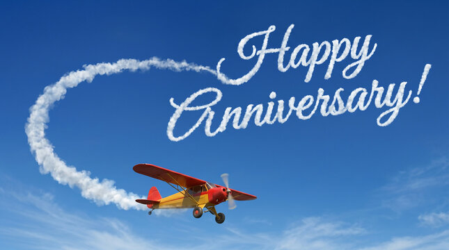 Happy Anniversary Skywriting with Yellow and Red Propeller Airplane, Creative Celebration Card Background in Clear Blue Sky with Smoke Trail
