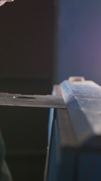 Worker bending the flat metal part with a special manual machine