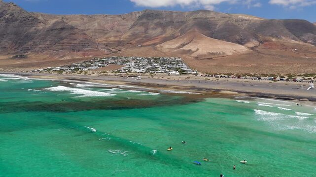 Aerial Flyover above  Famara Beach Cliffs and Coastal Village in Northwest Lanzarote