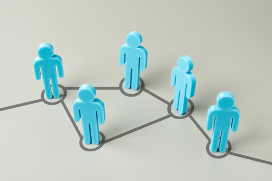 Blue figures connected by a digital network line on a grey background. Social networking, organizational structure, corporate communication concept.