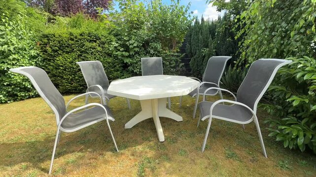 Empty summer garden table with chairs on a sunny day