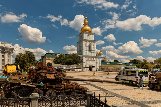 Kyiv, Ukraine - 11 June 2026: View of St. Michaels Golden-Domed Monastery with destroyed military tanks on display in the foreground under a blue sky with clouds.