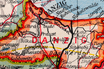 Macro close-up of a vintage map fragment showing Danzig, modern Gdansk, with surrounding Baltic region place names, route lines and aged paper texture. © Studio Aurelia