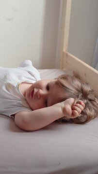 Toddler relaxing comfortably in bedroom during quiet moment at home, highlighting childhood security, wellbeing, rest and peaceful family living