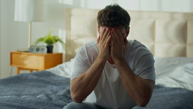 Angry Caucasian man receiving bad news on smartphone feeling frustrated male throwing mobile phone at home bedroom guy upset by notification bankruptcy divorce irritation stress problem crisis indoors