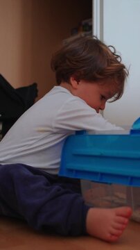 Young child sorting through toy container during independent floor play, highlighting exploration, decision making, creativity and early childhood development