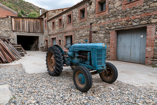 Tractor by stone buildings in the country
