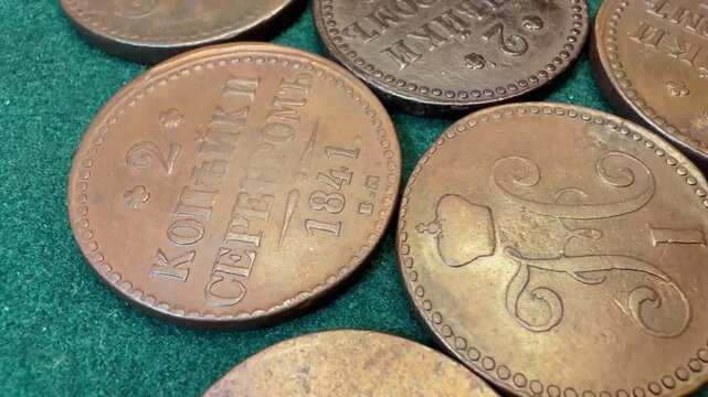 Close-up of old copper 2 kopeck coins 1839-1848 Russian Empire Nicholas I on green fabric, showing worn details, vintage money, collecting, history, and antique currency in a simple still life scene.