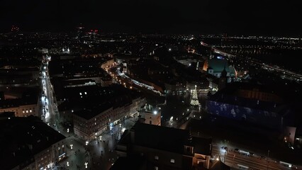 Obraz premium Night cityscape with illuminated buildings and streets