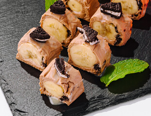 Sweet dessert banana sushi with chocolate cookies and mint © AntAlexStudio