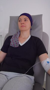Female patient receiving intravenous therapy in outpatient treatment facility, medical recovery setting emphasizing care, endurance, healing and emotional strength