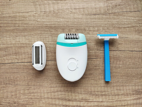 Epilator with attachment and disposable razors for hair removal and skin care. Home tools for female hygiene and beauty routine.	