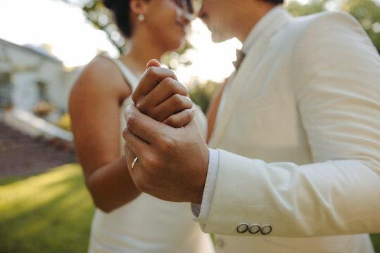 Couple holding hands during their wedding celebration outdoors