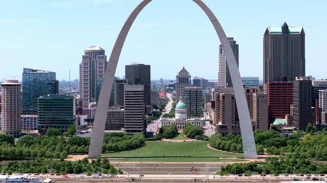 Over the Mississippi River, capturing the Gateway Arch and Old Courthouse against the backdrop of the St. Louis city skyline at daytime, ascending aerial view