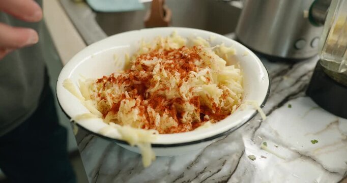 Caucasian man grate potato. Single male is cooking at kitchen at home. 4K 10-bit