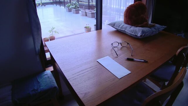 Envelope and pen prepared on a table with an outdoor view and a gentle breeze, quiet signs of daily life for writing, correspondence and home lifestyle use