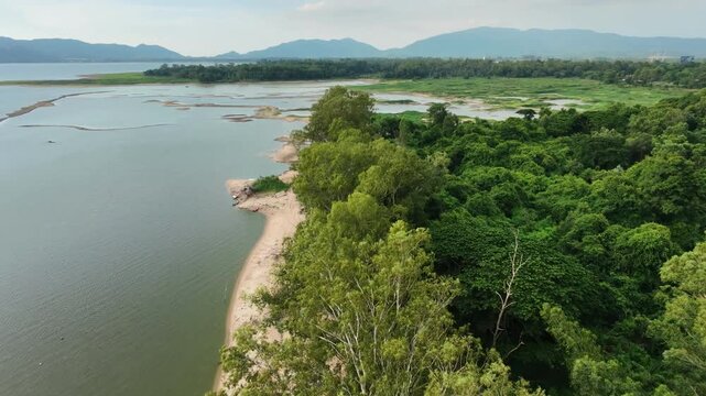 Aerial drone footage of a calm lake reflecting clouds and mountains at sunset light. Ideal for nature, travel, environment, wetland, and cinematic landscape projects.