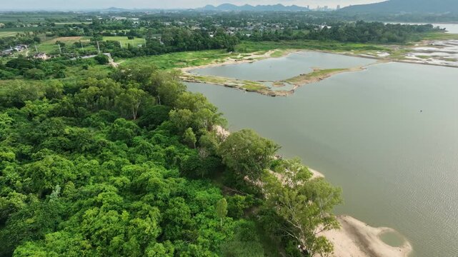 Aerial drone footage of a calm lake reflecting clouds and mountains at sunset light. Ideal for nature, travel, environment, wetland, and cinematic landscape projects.
