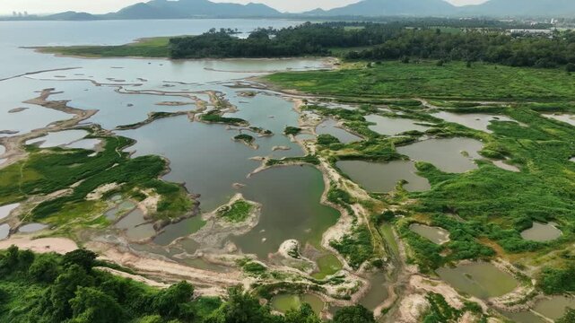 Aerial drone footage of a calm lake reflecting clouds and mountains at sunset light. Ideal for nature, travel, environment, wetland, and cinematic landscape projects.