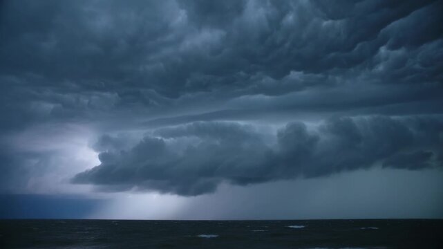 Rolling large shelf cloud moving over dark sea, lightning illuminating and rain curtains descending